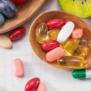 Closeup shot of fresh fruits with different medicine on a wooden spoon A closeup shot of fresh fruits with different medicine on a wooden spoon